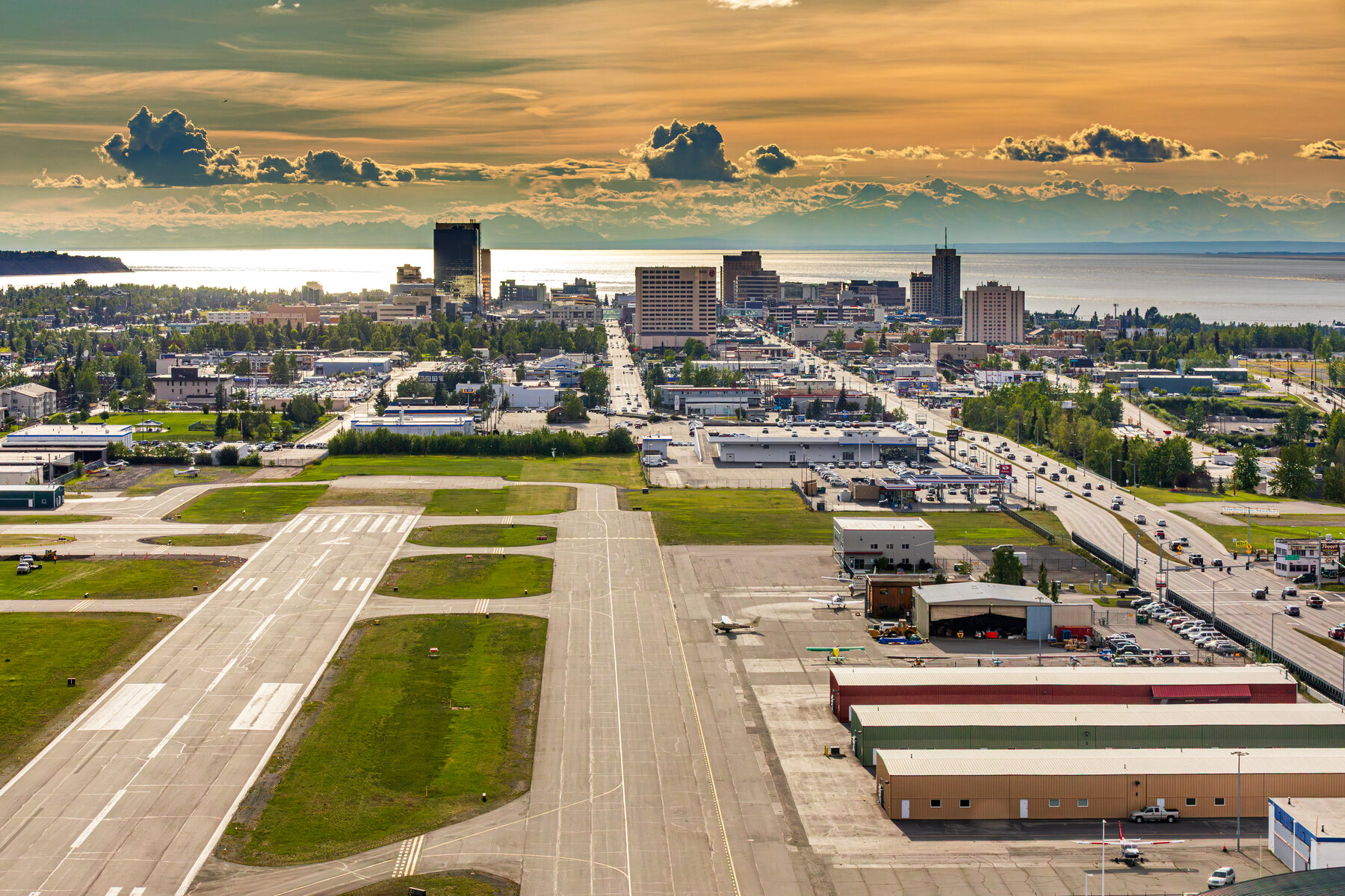 Aerial view of Anchorage at dusk with Cook Inlet and the Alaska Range behind