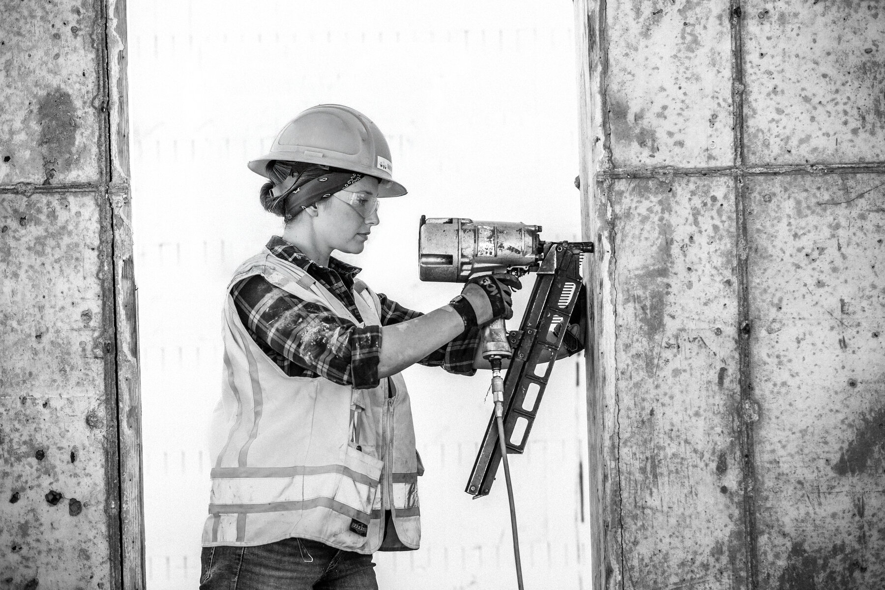 Construction worker operating a nail gun on a commercial build site